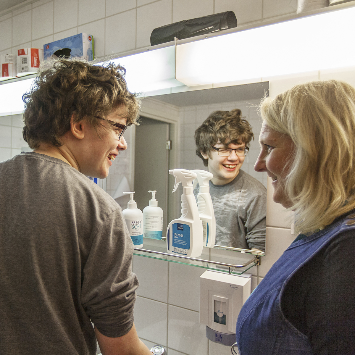 Opiskelija ja opettaja keskustelevat kylpyhuonetiloissa siivoamisesta.
